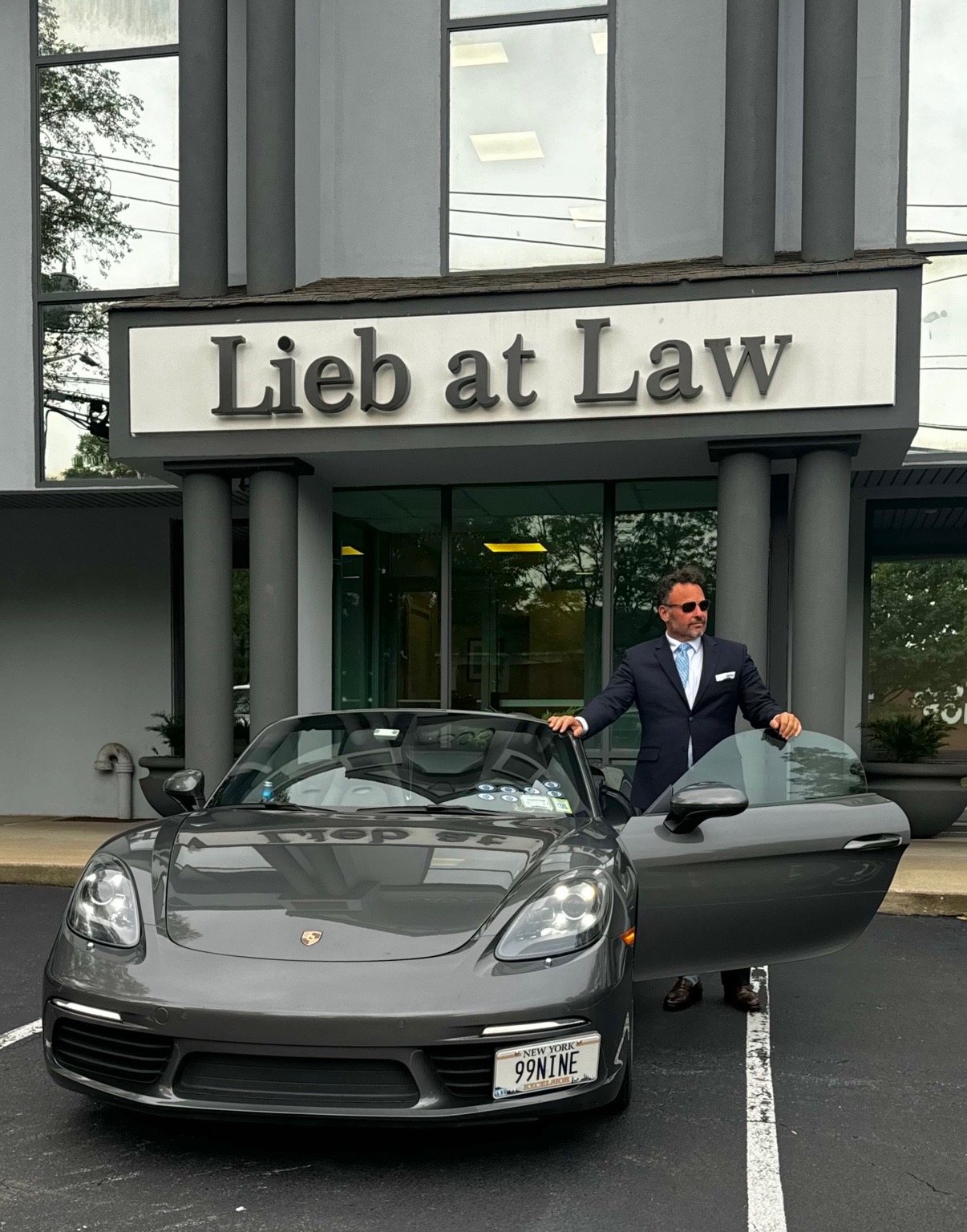 Mitchell Drucker outside the Lieb at Law office in Smithtown, New York, beside his Porsche 718